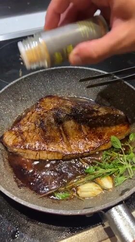 Steak seasoning in progress on a Milan stovetop