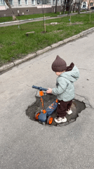 Toddler rides scooter through Klin streets during family outing