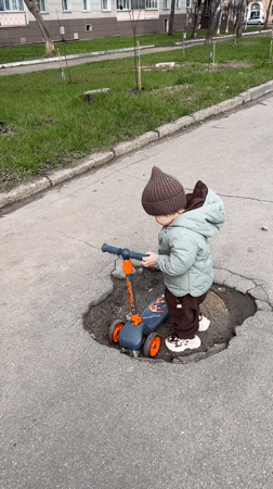 Toddler rides scooter through Klin streets during family outing