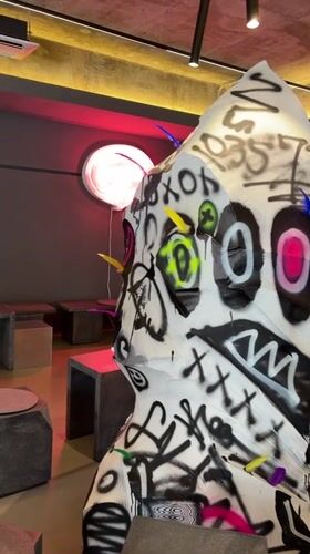 Graffiti-marked abstract sculpture observed in Seoul interior space