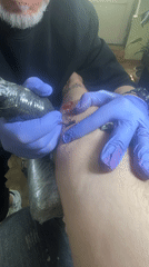 Tattoo artist works on foot design in Tbilisi