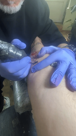 Tattoo artist works on foot design in Tbilisi