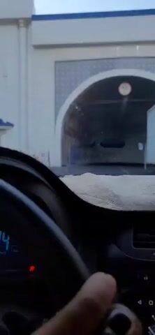The video shows a first-person perspective of a vehicle entering a tunnel. The tunnel is illuminated by lights along its length, and there are some vehicles visible ahead. A sign at the entrance of the tunnel indicates a height restriction of 4.5 meters. The dashboard of the car is visible, with a beige dash cover and a blue air freshener. The driver's hand is occasionally visible on the steering wheel. The tunnel walls are made of concrete and appear to be reinforced with metal structures. The overall impression is of driving through an urban or highway tunnel.