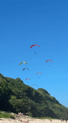 Morning beach life: swimmers, paragliders enjoy Kuta Selatan waters
