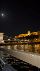 Tourist captures illuminated Budapest landmarks from Danube River boat