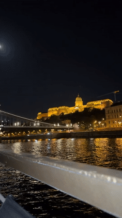 Tourist captures illuminated Budapest landmarks from Danube River boat