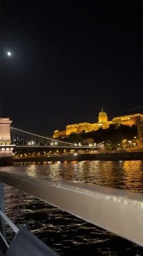 Tourist captures illuminated Budapest landmarks from Danube River boat