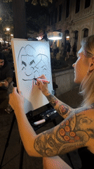 Caricature artist draws two-person portrait outdoors in Belgrade at night