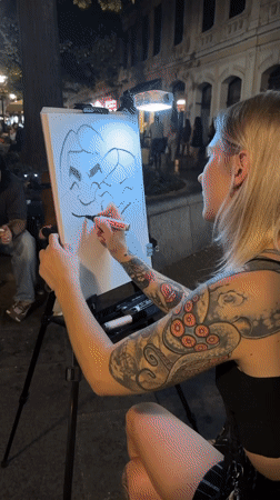 Caricature artist draws two-person portrait outdoors in Belgrade at night