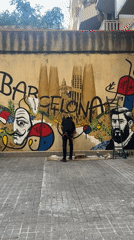 Artist spray paints Barcelona mural featuring Dali, Sagrada Familia