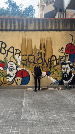 Artist spray paints Barcelona mural featuring Dali, Sagrada Familia