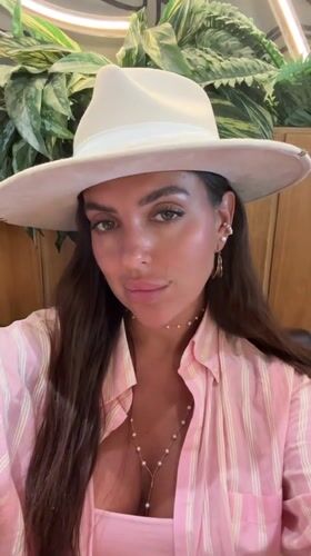 Woman takes selfies in fedora and stripes in Dubai