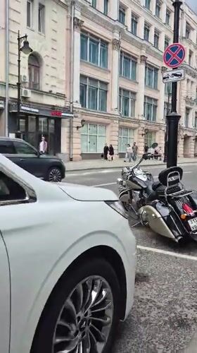 Street-level Moscow: mixed architecture, parked vehicles, docked scooters