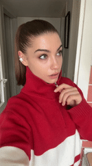 Woman adjusts sweater zipper indoors in Moscow