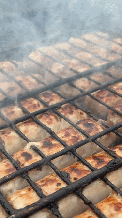 Sausages grilling over coals captured by witnesses May 30
