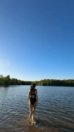 Woman enjoys afternoon swim at forest lake in Chernushka