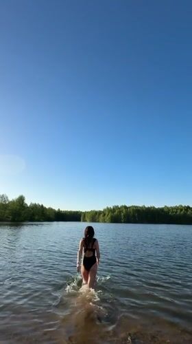 Woman enjoys afternoon swim at forest lake in Chernushka