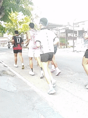 Six Young Men Running Along Paved Road During Daylight