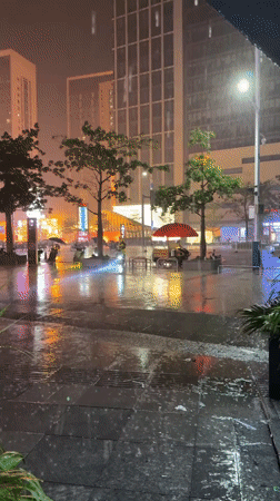 Rainy night lights reflect off wet streets in Panyu District