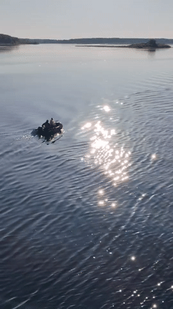 Two-person inflatable boat crosses water near Pochinok, Russia