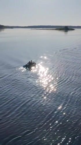 Two-person inflatable boat crosses water near Pochinok, Russia