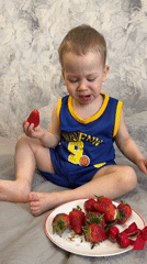 Toddler enjoys early morning fruit snack in Rusanovo