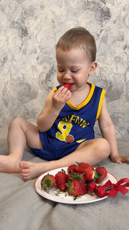 Toddler enjoys early morning fruit snack in Rusanovo