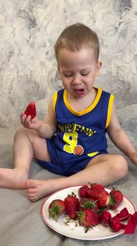 Toddler enjoys early morning fruit snack in Rusanovo
