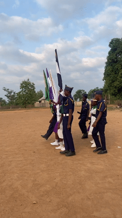 Uniformed group holds ceremonial formation with flags in Andaha