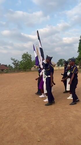 Uniformed group holds ceremonial formation with flags in Andaha