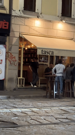 Evening street life documented around Milan's ancient Roman columns