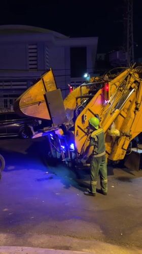 Night garbage collection on a Nha Trang street, dog included