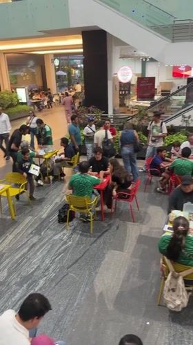 Late-night gathering in Puebla mall features green-shirted participants