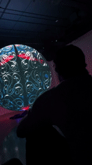 Person views colorful spherical display in darkened Saint Petersburg room