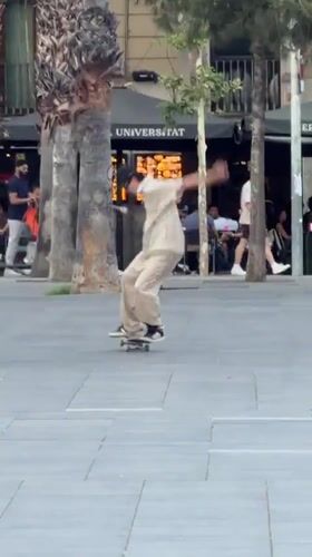 Skateboarders perform tricks in Barcelona plaza during evening session