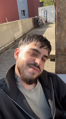 Man gives thumbs-up gesture in sunny Frankfurt street