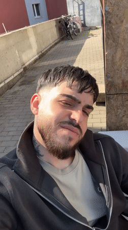 Man gives thumbs-up gesture in sunny Frankfurt street