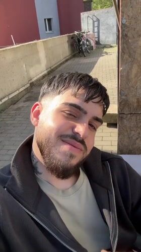 Man gives thumbs-up gesture in sunny Frankfurt street