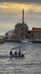 Motorboat carries passengers across Petrovac harbor, Montenegro