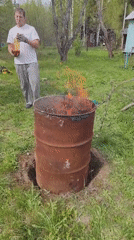 Man burns debris in yard with outdoor refreshment setup