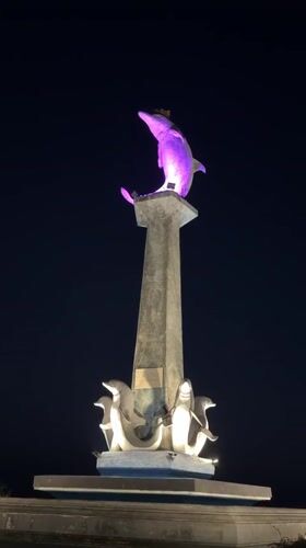 Lovina Beach's dolphin monument glows through its full color cycle at night