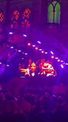 Crowd gathers at illuminated Canadian Parliament Buildings with stage setup