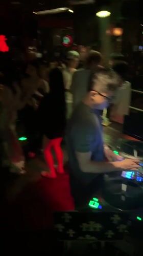 DJ set underway at a Liangjiang nightclub, red and green lights