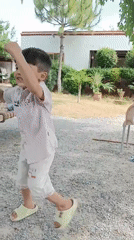 Child plays in yard with chickens in Pakistan