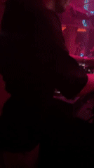 DJ performs at nightclub amid colorful lights and atmosphere