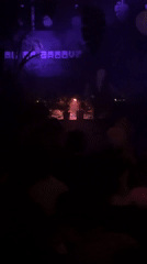 DJ performs at nightclub with colorful lighting effects