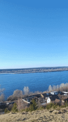 Person surveys Volga River landscape from hillside in Noviy
