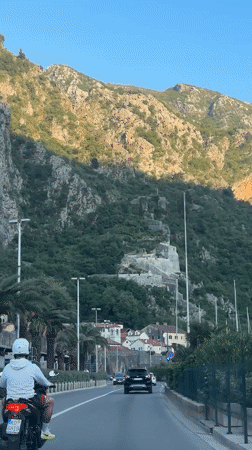 Motorcyclist travels scenic coastal road in Kotor, Montenegro
