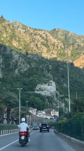 Motorcyclist travels scenic coastal road in Kotor, Montenegro