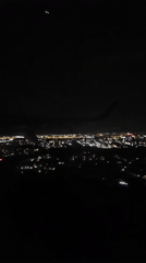 Passenger films nighttime aerial view of illuminated Bucharest from airplane